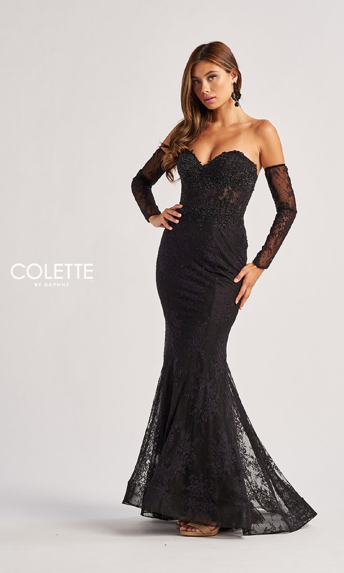 A woman wears the Strapless Long Lace Prom Dress: Colette CL8415 with matching lace sleeves, standing against a plain light background. The image features the text
